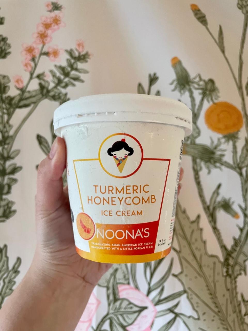 Writer holding up a carton of turmeric honeycomb ice cream