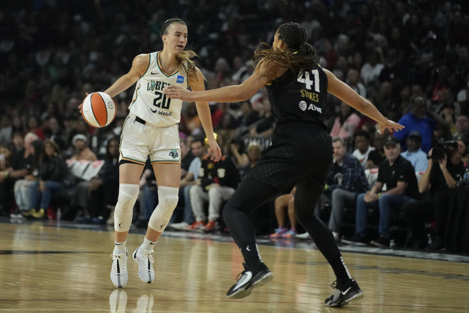 New York Liberty guard Sabrina Ionescu (20) drives against Las Vegas Aces center Kiah Stokes (41) during the first half in Game 1 of a WNBA basketball final playoff series Sunday, Oct. 8, 2023, in Las Vegas. (AP Photo/John Locher)