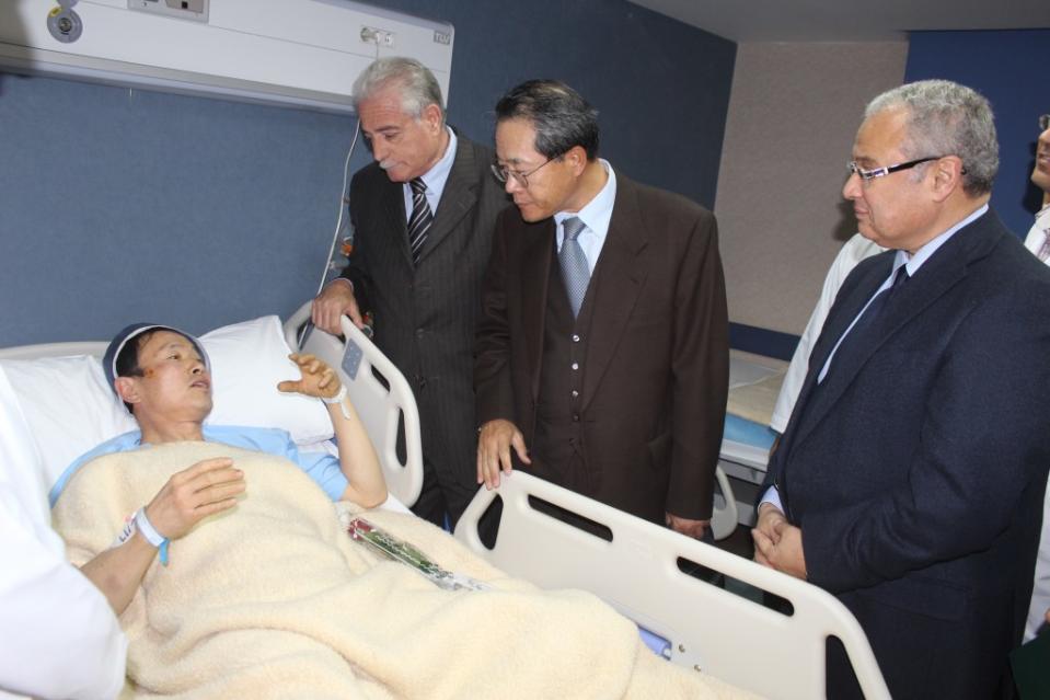 In this photo released by the office of the South Sinai governor, Egyptian Minister of Tourism Hesham Zazou, right, Deputy Chief of Mission of the South Korean Embassy in Egypt, Mr. Kwon Sae Young, second right, and South Sinai governor Major General Khaled Foda, visit a South Korean tourist who was injured during an explosion that targeted a tourist bus, as he received medical treatment in Sharm El-Sheik hospital, in Egypt, late Sunday, Feb. 16, 2014. An explosion ripped through a tourist bus near a border crossing between Egypt and Israel in the Sinai Peninsula, killing several South Koreans and the Egyptian driver, security officials said. (AP Photo/Office of the South Sinai governor)