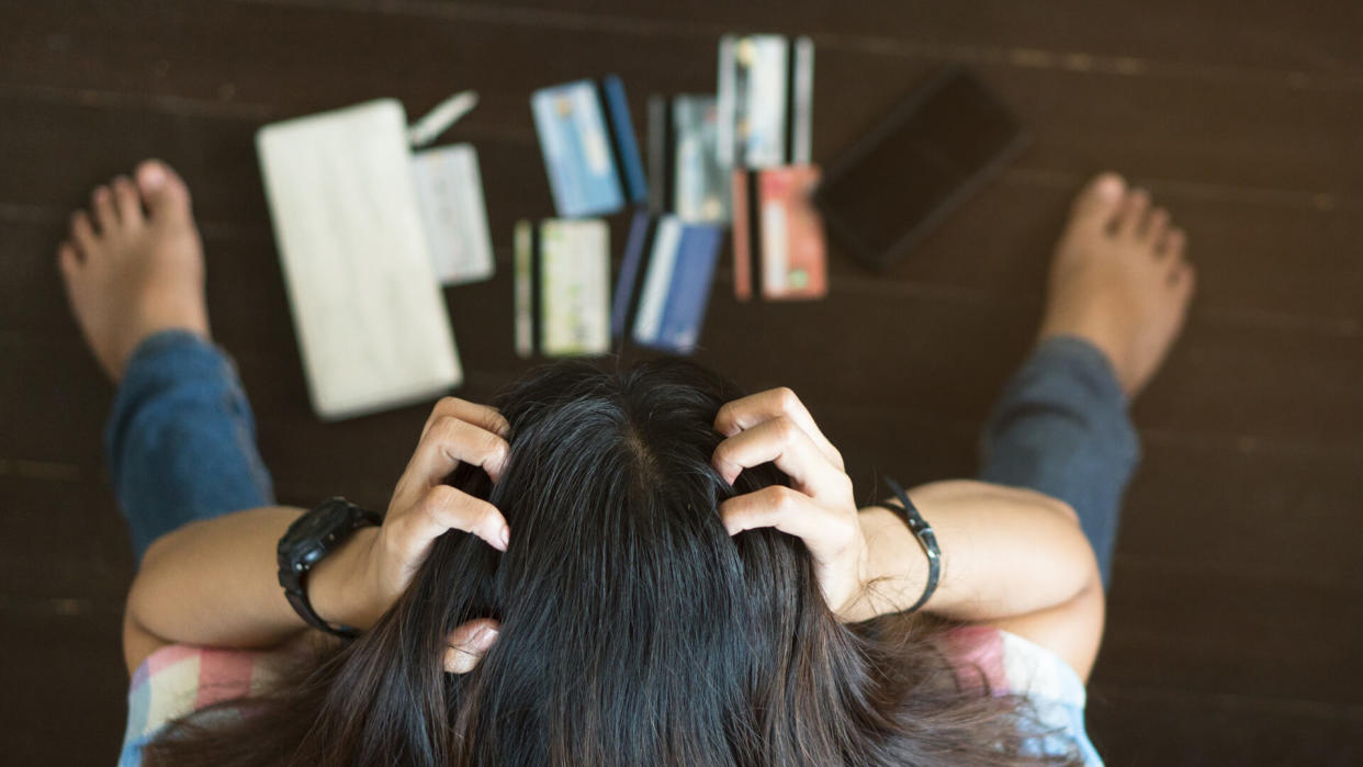 Top view of stressed  woman trying to find money to pay credit card debt.