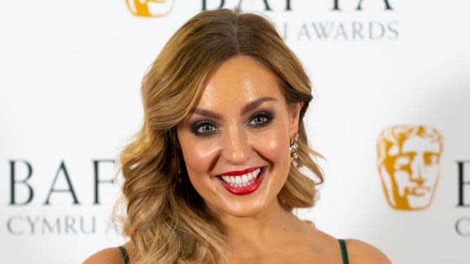 Amy Dowden appeared at the Welsh Baftas, her hair is curled and down and she is wearing red lipstick