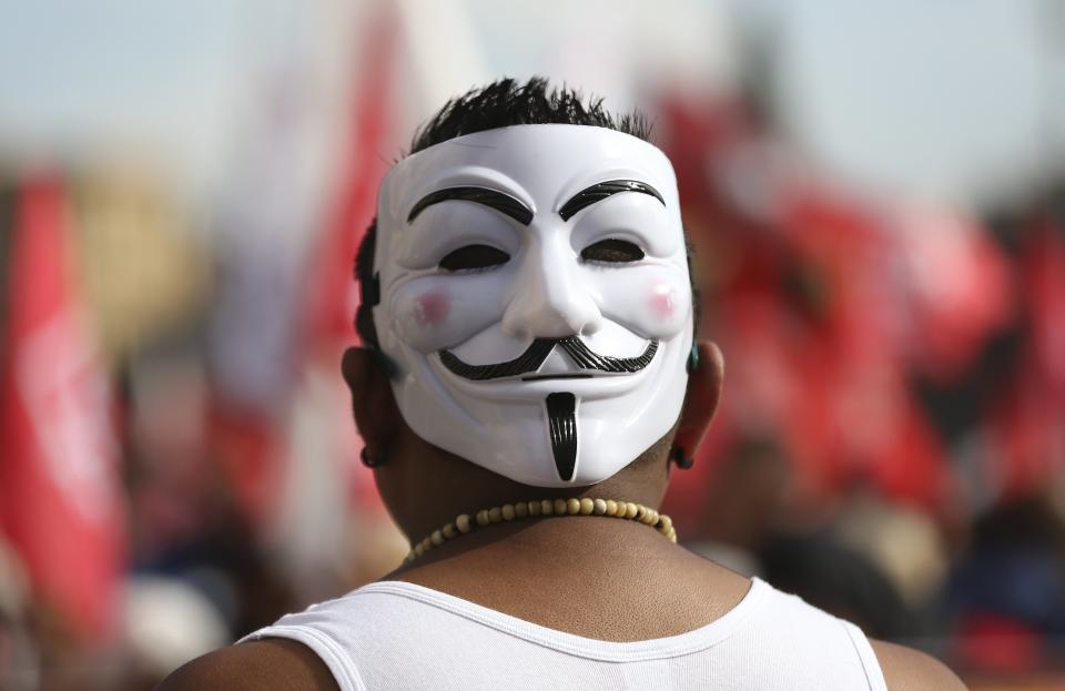 Demonstrator wears a Guy Fawkes mask on the back of his head during a protest in downtown Rome