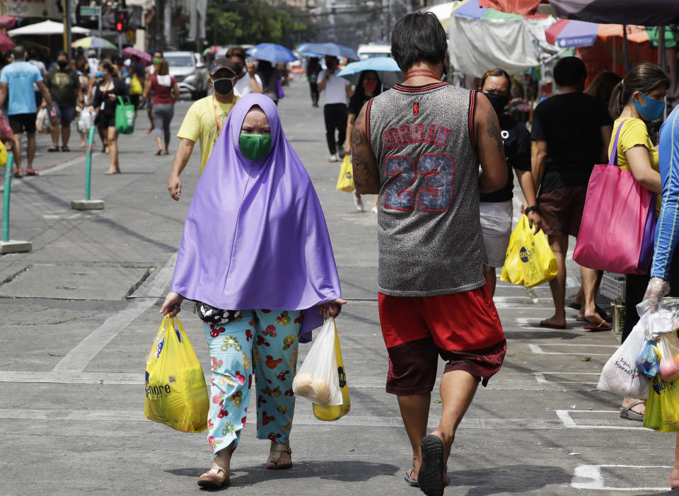 A Muslim woman wears a protective mask as she goes to a public market during an enhanced community quarantine to prevent the spread of the new coronavirus in Manila, Philippines on Thursday April 23, 2020. (AP Photo/Aaron Favila)