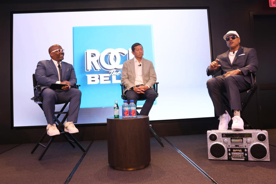 Loren Hammonds, Geoff Yang, and hip-hop artist LL Cool J sit together at The NASDAQ Opening Bell.