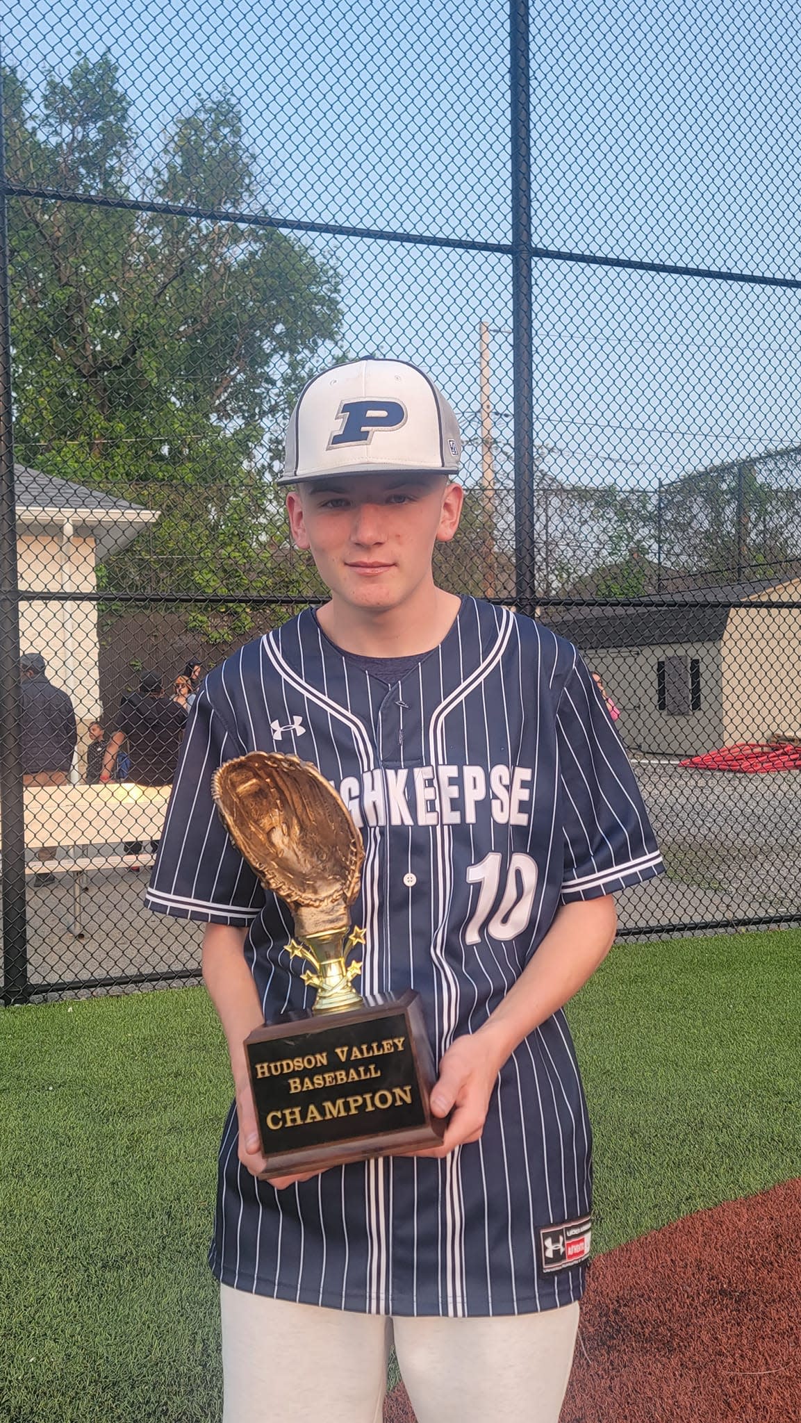Poughkeepsie baseball player Corey Martin poses with the Hudson Valley Baseball championship trophy on May 10, 2023.