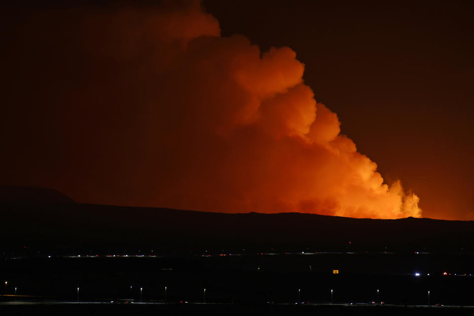 The night sky is illuminated caused by the eruption of a volcano on the Reykjanes peninsula of south-west Iceland seen from the capital city of Reykjavik, Monday Dec. 18, 2023. (AP Photo/Brynjar Gunnarsson)