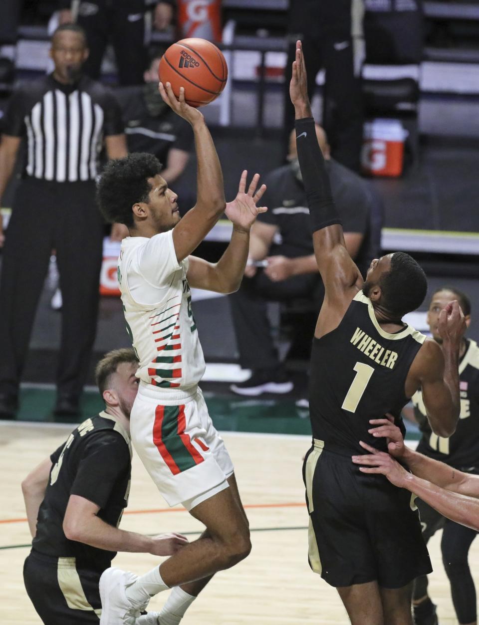 Miami guard Harlond Beverly (5) shoots over Purdue forward Aaron Wheeler (1) during the first half of an NCAA college basketball game Tuesday, Dec. 8, 2020, in Coral Gables, Fla. (Al Diaz/Miami Herald via AP)