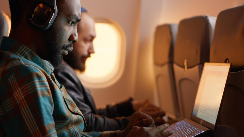 A man on his laptop on a plane