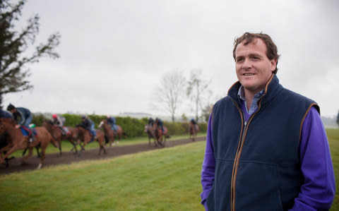 Richard Hannon watches some of his horses go out for a morning run - Credit: Action images