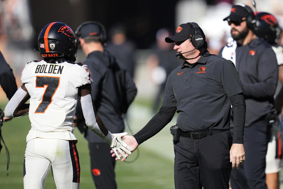 Oregon State head coach Jonathan Smith, right, slaps hands with Oregon State wide receiver Silas Bolden (7) after an Oregon State score against Arizona State during the second half of an NCAA college football game in Tempe, Ariz., Saturday, Nov. 19, 2022. Oregon State won 31-7. (AP Photo/Ross D. Franklin)