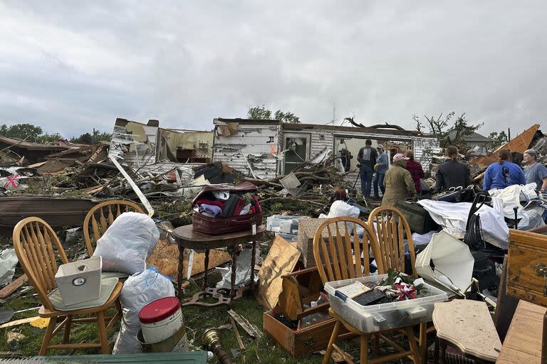 Un grupo de personas examina los daños causados por un tornado en Greenfield, Iowa, el martes 21 de mayo de 2024. (AP Photo/Hannah Fingerhut)