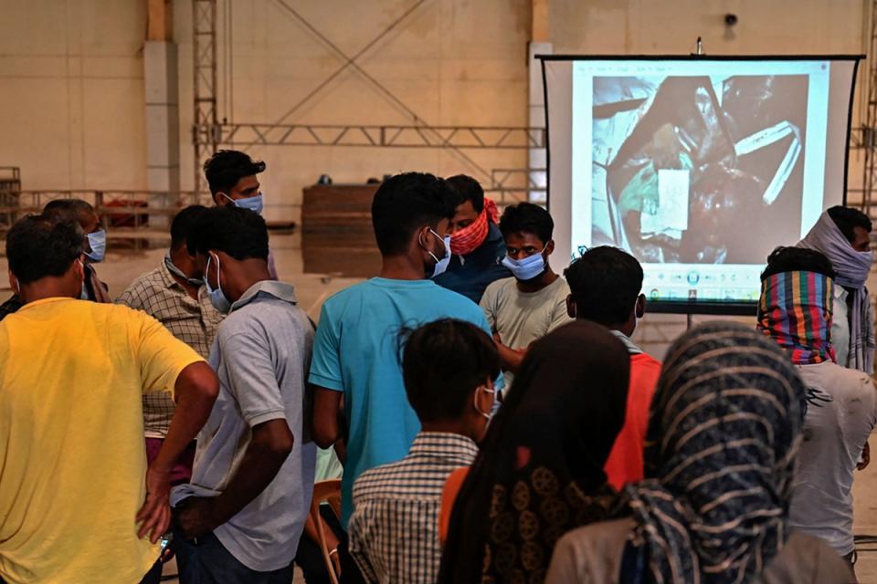 Large television screens show pictures of unidentified bodies for family members to assist in identifcation (AFP via Getty Images)