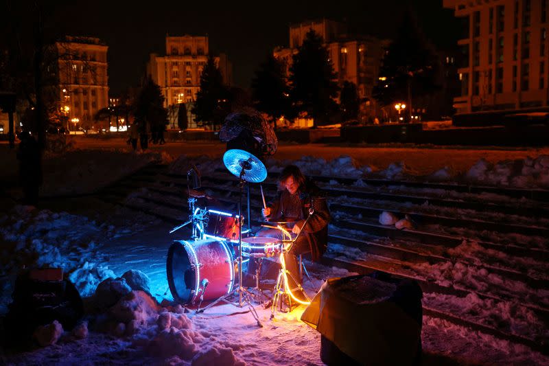 A street musician plays during snowfall as power outages continue in Kyiv, Ukraine