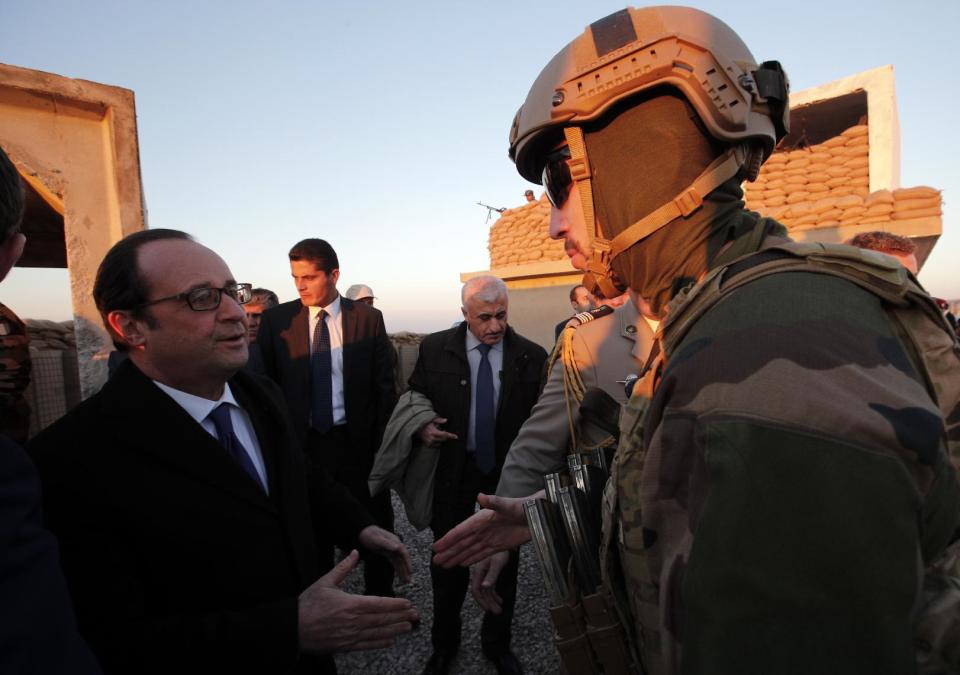 French President Francois Hollande shakes hands with a French soldier as he visits a military outpost on the outskirts of the Islamic State-held city of Mosul, outside the Kurdish city of Irbil, Iraq, Monday, Jan. 2, 2017. Hollande is in Iraq for a one-day visit. (AP Photo/ Christophe Ena, Pool)