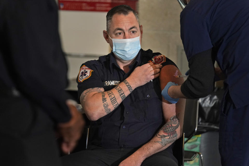 New York City firefighter emergency medical services personnel are vaccinated against COVID-19 at the FDNY Fire Academy in New York, Wednesday, Dec. 23, 2020. (AP Photo/Seth Wenig)