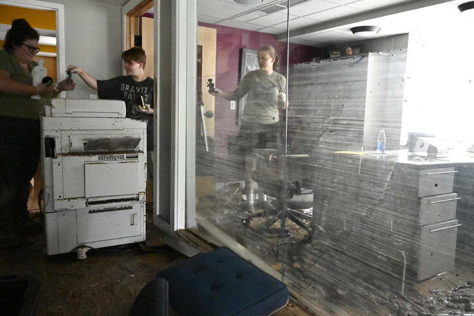 Employees of the Hindman Settlement School clean out the offices of the school following flooding in Hindman, Ky., Friday, July 29, 2022. Water reached a height of approximately 4 and a half feet in the school. (AP Photo/Timothy D. Easley)