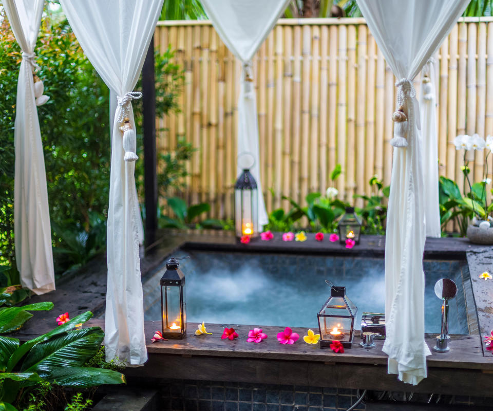 tropical inspired hot tub with privacy curtains