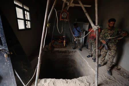 Syrian Democratic Forces fighters inspect a tunnel dug by Islamic State militants inside a house in Raqqa's al-Sanaa industrial neighborhood. REUTERS/Rodi Said