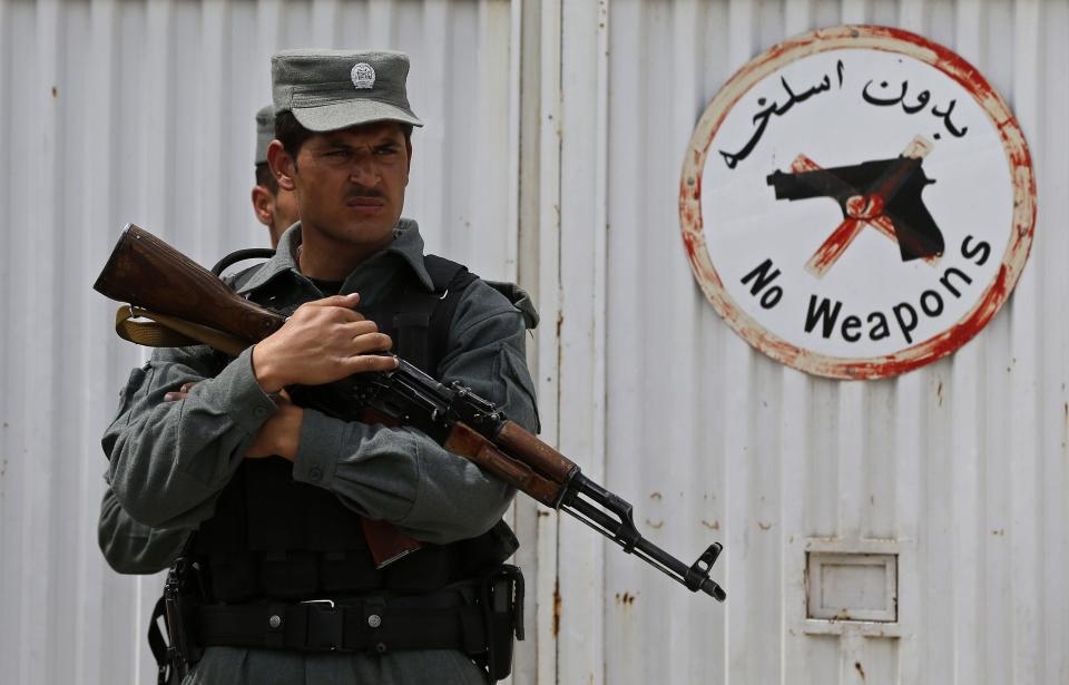 An Afghan policeman stands at the gate of Cure Hospital after three Americans were killed in Kabul April 24, 2014. Three American doctors were killed on Thursday when a security guard opened fire at a Kabul hospital funded by a U.S. Christian charity, in the latest of a spate of attacks on foreign civilians in Afghanistan. The shooting occurred in the grounds of the Cure Hospital which specializes in children's and maternal health. (REUTERS/Omar Sobhani)