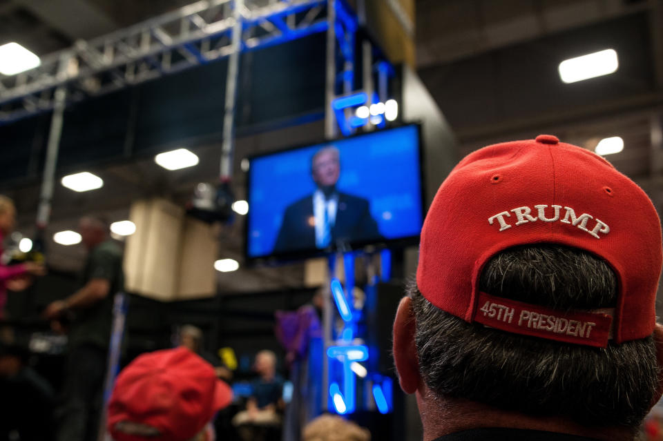 A crowd watches a screen showing a live feed of Trump's speech on&nbsp;Friday.