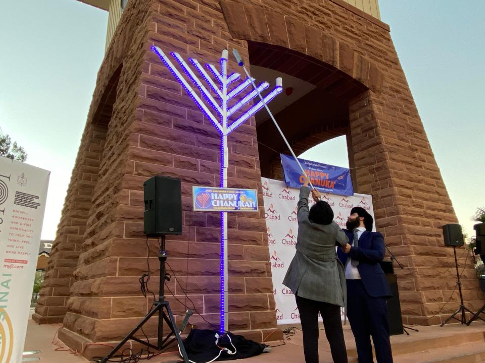 Mayor Michele Randall, left, of St. George, Utah, and Rabbi Mendy Cohen of the Chabad Jewish Center, participate in the city's 4th annual Menorah Lighting celebration.