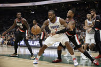 Los Angeles Clippers' Kawhi Leonard (2) draws a foul from Portland Trailblazers' Damian Lillard, behind, during the first half of a preseason NBA basketball game, Monday, Oct. 3, 2022, in Seattle. (AP Photo/ John Froschauer)