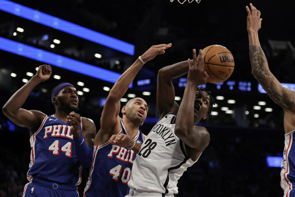 Brooklyn Nets forward Dorian Finney-Smith passes in front of Philadelphia 76ers forward Nicolas Batum (40) during the first half of an NBA basketball game Tuesday, March 5, 2024, in New York. (AP Photo/Adam Hunger)