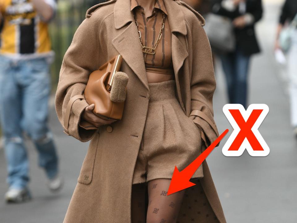 red x and arrow pointing at skin toned patterned tights someone is wearing with a neutral outfit walking down the street