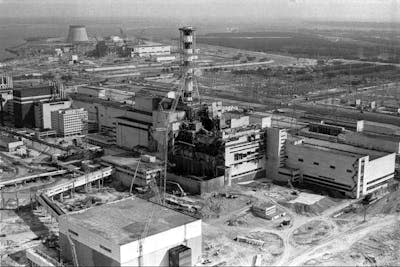 A black and white photo showing a large explosion hole in a building, from an overhead view.