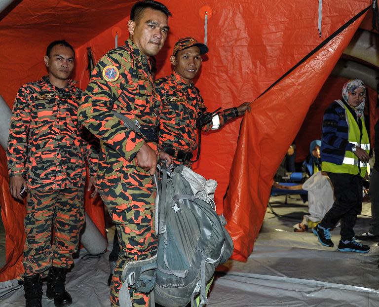 A Malaysian soldier carries victims body parts inside a rucksack, a day after a powerful earthquake Mount Kinabalu, on June 6, 2015