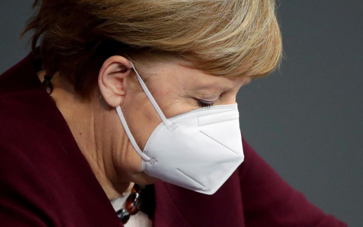 FILE PHOTO: German Chancellor Angela Merkel wears a protective face mask after delivering a speech on the government's response to the coronavirus disease (COVID-19) pandemic in the country's parliament, the Bundestag, in Berlin, Germany, November 26, 2020. REUTERS/Hannibal Hanschke/File Photo -  HANNIBAL HANSCHKE/ REUTERS