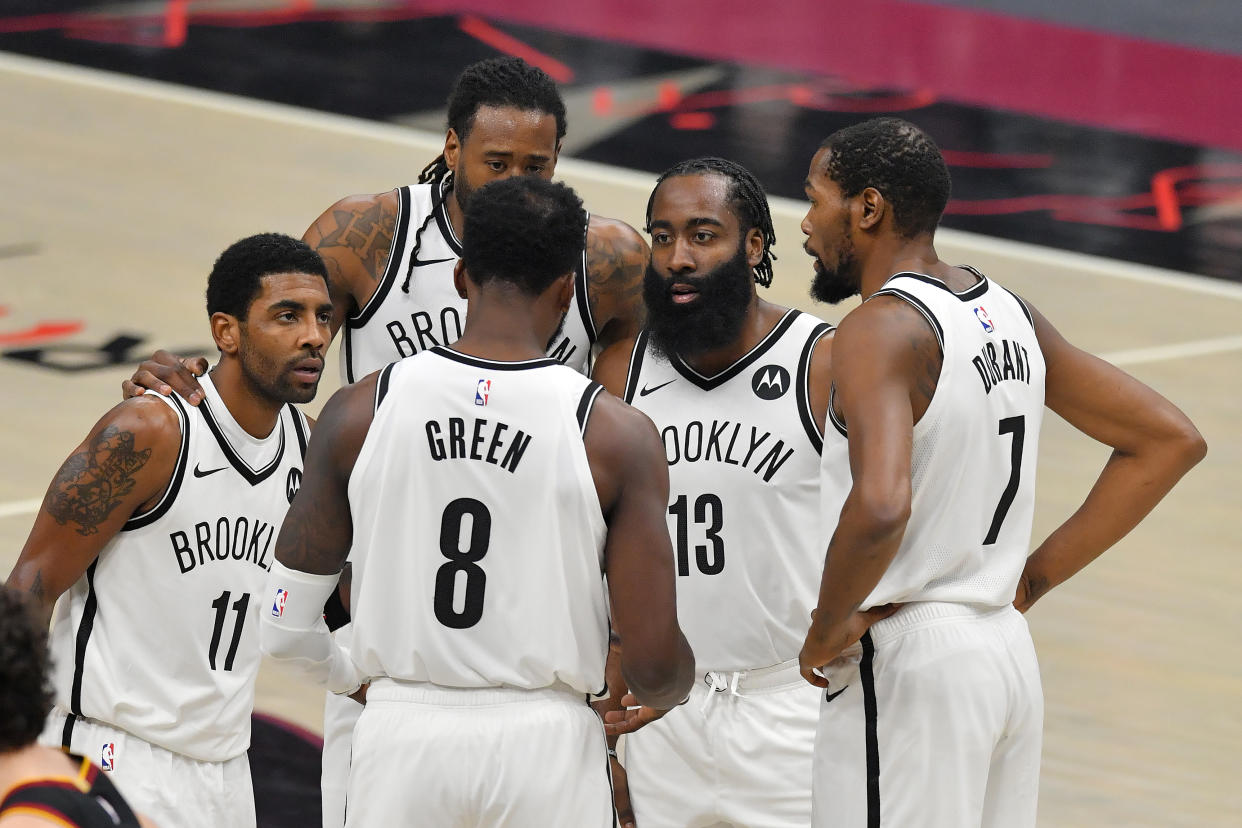 Kyrie Irving, DeAndre Jordan, Jeff Green, James Harden and Kevin Durant huddle on the court during a game.