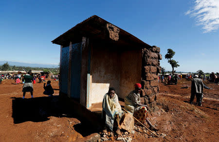 Survivors sit outside their destroyed house after a dam burst, which unleashed water at nearby homes, in Solio town near Nakuru, Kenya May 10, 2018. REUTERS/Thomas Mukoya
