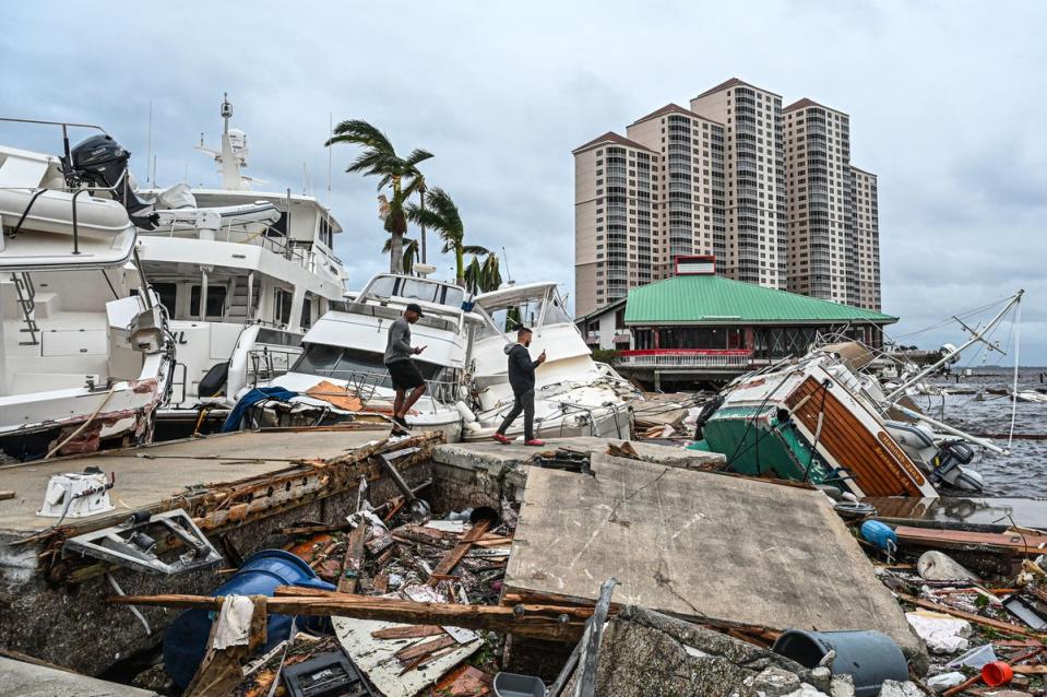 Residents inspect damage to a marina as boats are partially submerged in the aftermath of Hurricane Ian in Fort Myers, Florida, in September. (AFP via Getty Images)