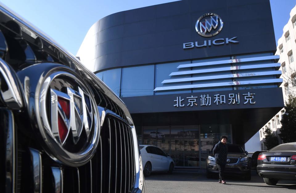 A woman stands outside a Buick showroom in Beijing on December 15, 2016.