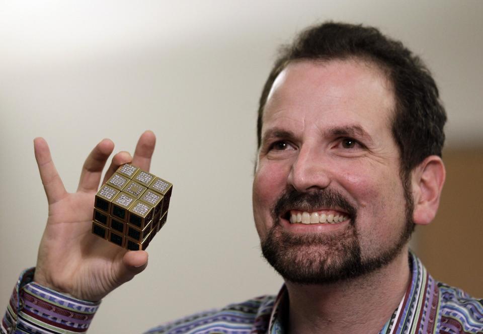 Jeweler Fred Cuellar holds a gold and gemstone version of the Rubik's Cube at Liberty Science Center, Wednesday, April 25, 2012, in Jersey City, N.J. The center will have an exhibit on the toys and will include the diamond version, which is worth 2.5 million dollars. (AP Photo/Julio Cortez)