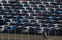 FILE PHOTO - A worker cycles past newly produced cars at an industrial port in Kawasaki, Japan, October 24, 2016. REUTERS/Kim Kyung-Hoon/File Photo