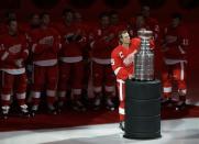 Detroit Red Wings captain Nicklas Lidstrom, of Sweden, holds the Stanley Cup trophy during the teams championship banner-raising prior to their NHL hockey season-opener against the Toronto Maple Leafs in Detroit, Thursday, Oct. 9, 2008. (AP Photo/Paul Sancya)