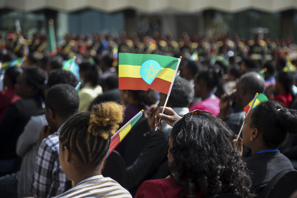 FILE - A member of the audience holds a national flag at a ceremony to remember those soldiers who died on the first day of the Tigray conflict, outside the city administration office in Addis Ababa, Ethiopia on Nov. 3, 2022. Eritrean troops and forces from the Amhara region, who have been fighting on the side of Ethiopia's federal military in the Tigray conflict, have been looting property and carrying out mass detentions in Tigray in Nov. 2022, according to eyewitnesses and aid workers. (AP Photo, File)