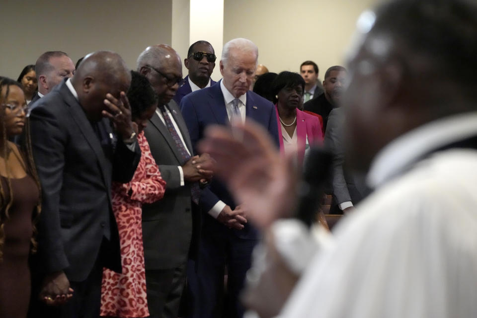 President Joe Biden, standing in front row at right, bows his head as Reverend Dr. Jamey O. Graham Sr., in foreground at right, speaks at St. John Baptist Church, in Columbia, S.C., on Sunday, Jan. 28, 2024. To the left of Biden is Rep. Jim Clyburn, D-S.C. (AP Photo/Jacquelyn Martin)