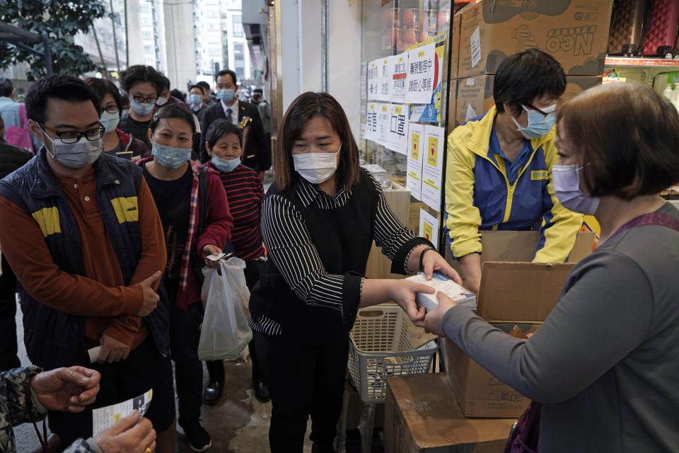 People queue up to buy face masks in Hong Kong, Friday, Feb. 7, 2020. Japan on Friday reported 41 new cases of a virus on a quarantined cruise ship and turned away another luxury liner while the death toll in mainland China rose to 636, including a doctor who got in trouble with authorities in the communist country for sounding an early warning about the disease threat. (AP Photo/Kin Cheung)