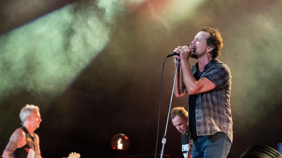 <div>Singer and guitarist Eddie Vedder (R) sings while guitarist Mike McCready (L) and bassist Jeff Ament (behind Eddie) play during a live Pearl Jam performance on August 8, 2018, in Seattle, Wash.</div> <strong>(Jim Bennett/Getty Images)</strong>