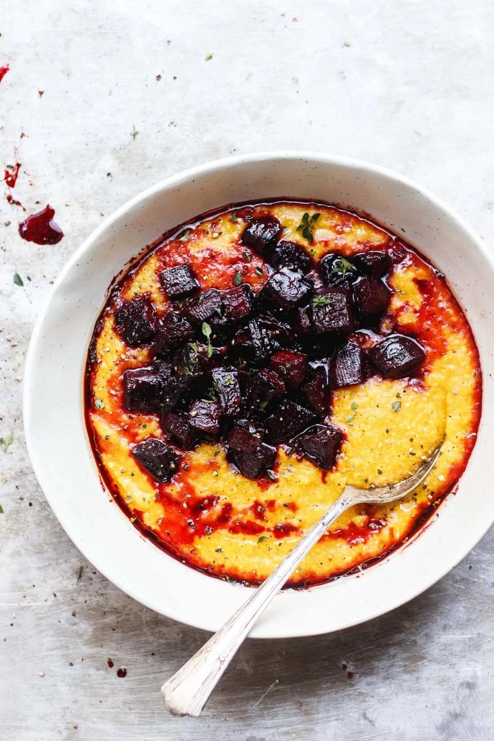 a bowl of pumpkin polenta with roasted beets sitting on top