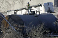 FILE - A cleanup worker stands on a derailed tank car of a Norfolk Southern freight train in East Palestine, Ohio, continues, Feb. 15, 2023. After the catastrophic train car derailment in East Palestine, Ohio, some officials are raising concerns about a type of toxic substance that tends to stay in the environment. (AP Photo/Gene J. Puskar, File)