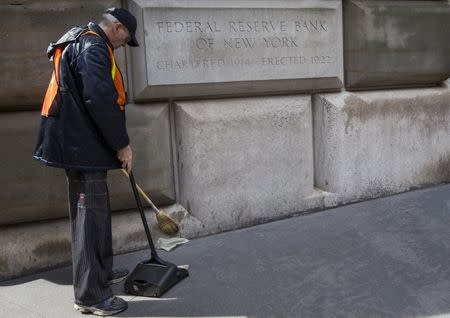A maintenance worker sweeps outside The New York Federal Reserve Bank in New York's financial district March 25, 2015. REUTERS/Brendan McDermid