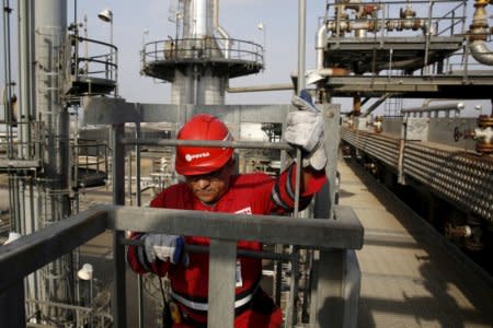 FILE PHOTO: An oilfield worker walks down the stairs, at Jose Antonio Anzoategui industrial complex of oil producer PDVSA in the state of Anzoategui, Venezuela April 15, 2015. REUTERS/Carlos Garcia Rawlins/File Photo