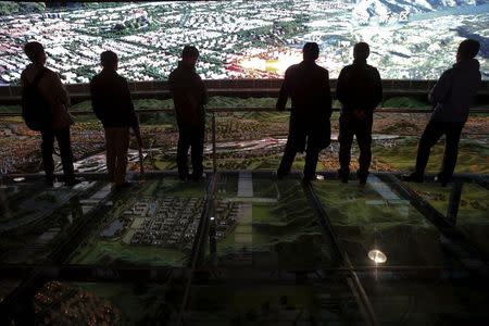 Planning projects are projected over a large model of Lhasa as a group of foreign reporters visits urban planing exhibition hall on a government organised trip in Lhasa, Tibet Autonomous Region, China in this November 19, 2015 file photo. REUTERS/Damir Sagolj/Files