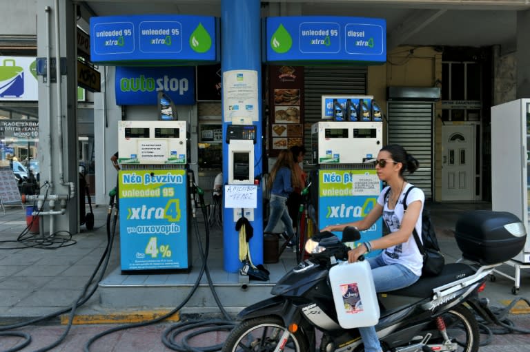 A motorcyclist rides past a closed petrol station in Thessaloniki