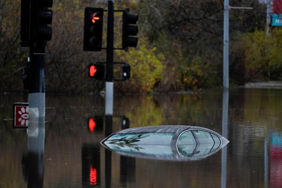 A car sits along a flooded road during a rain storm Monday, Jan. 22, 2024, in San Diego. Heavy rainfall around the U.S. on Monday prompted first responders in Texas to conduct water rescues and officials in California to issue evacuation warnings over potential mudslides in parts of Los Angeles County.