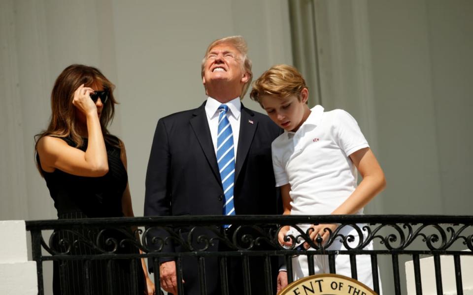 Without his protective glasses on, U.S. President Donald Trump looks up towards the solar eclipse in 2017